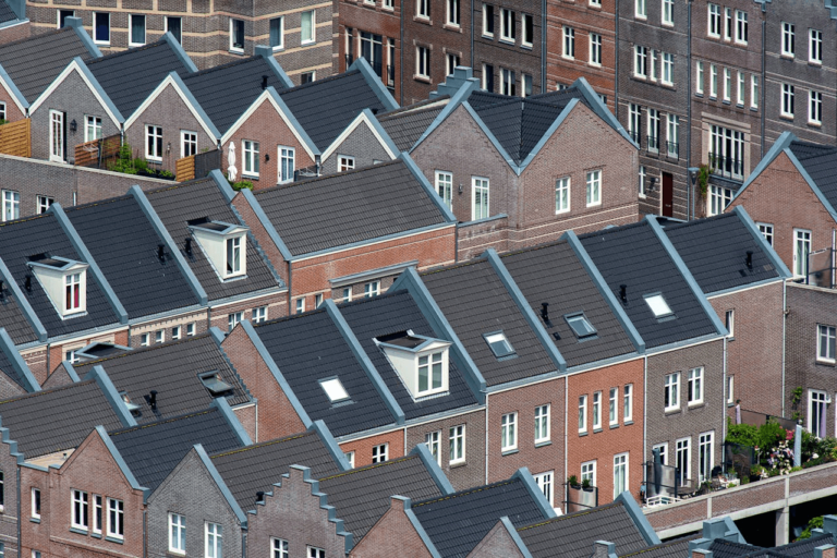 This image shows a dense cluster of residential brick houses with pitched roofs, skylights, and a consistent architectural style.