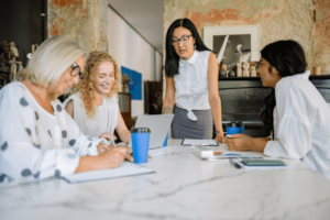 Photo of a team meeting with people discussing their company goals.